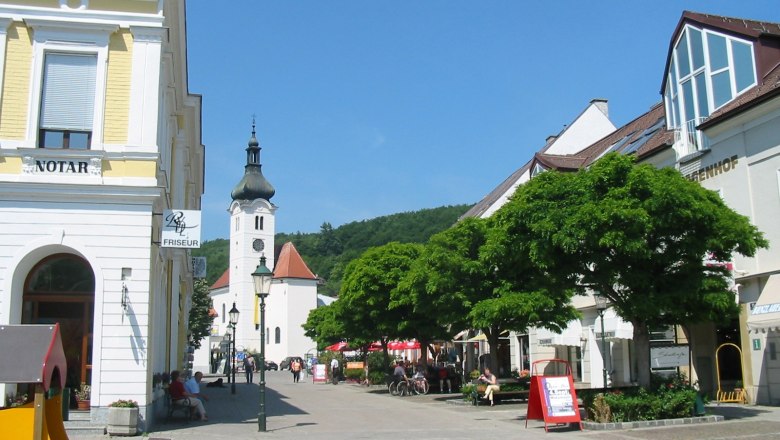 Hauptplatz Purkersdorf, © Purkersdorf Hauptplatz in Purkersdorf mit Kirche und Geschäften.
