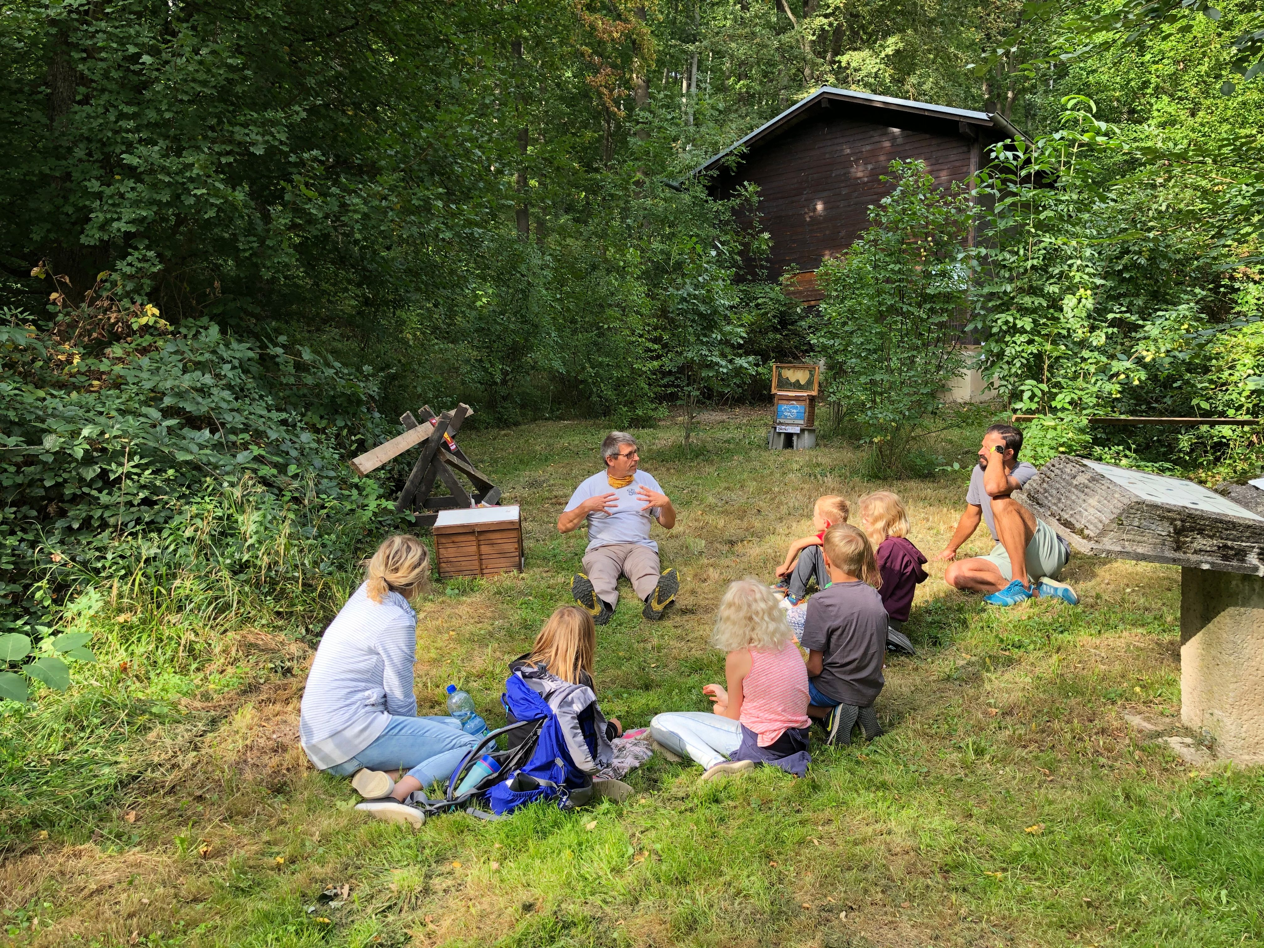 Naturparkfest Bienentour, Sitzkreis im Wald mit Imker, Kindern und Eltern