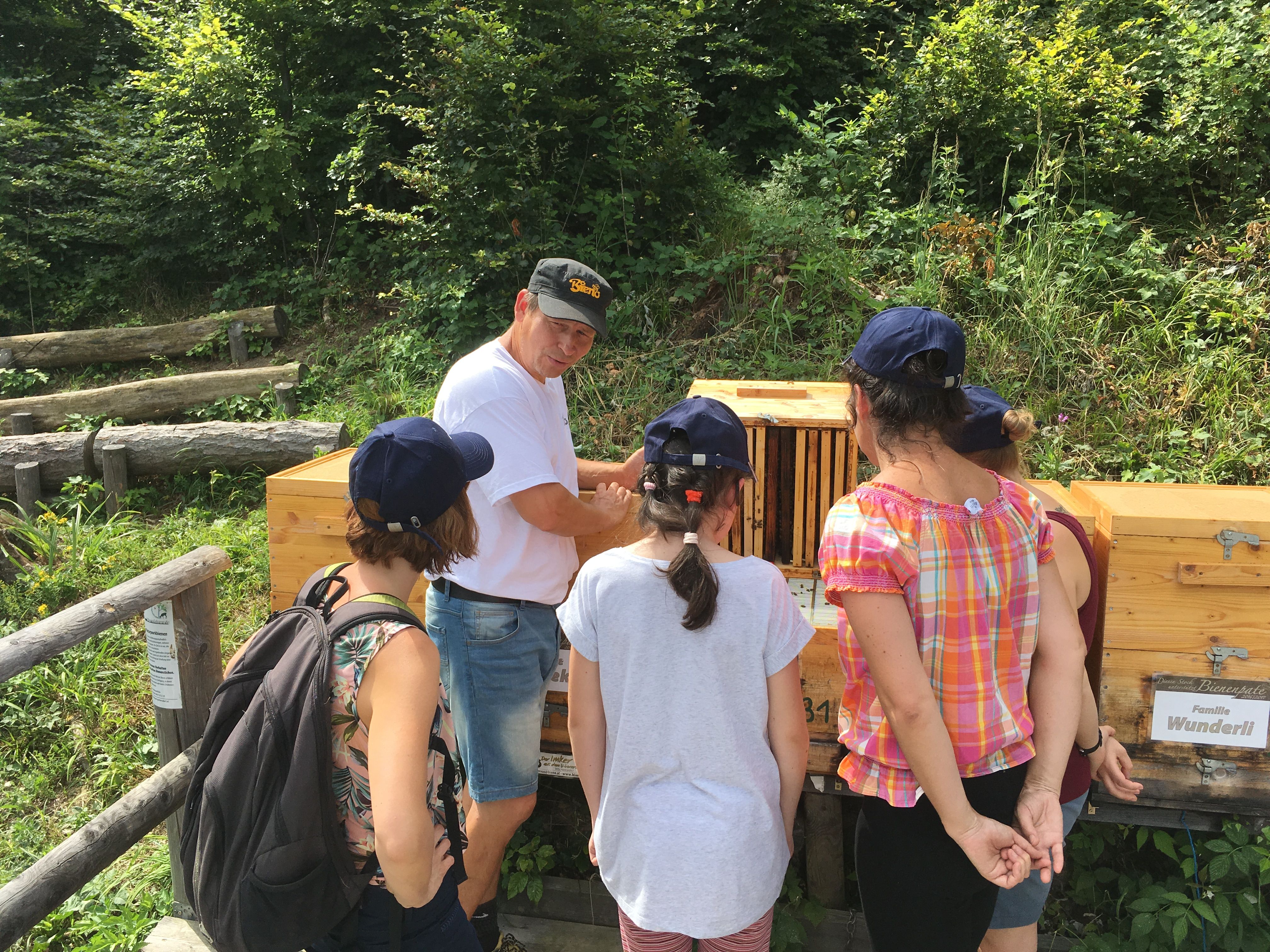 Naturpark Imker Bieno steht vor seinen Bienenstöcken/Bienenbeute und haltet einen Vortrag.