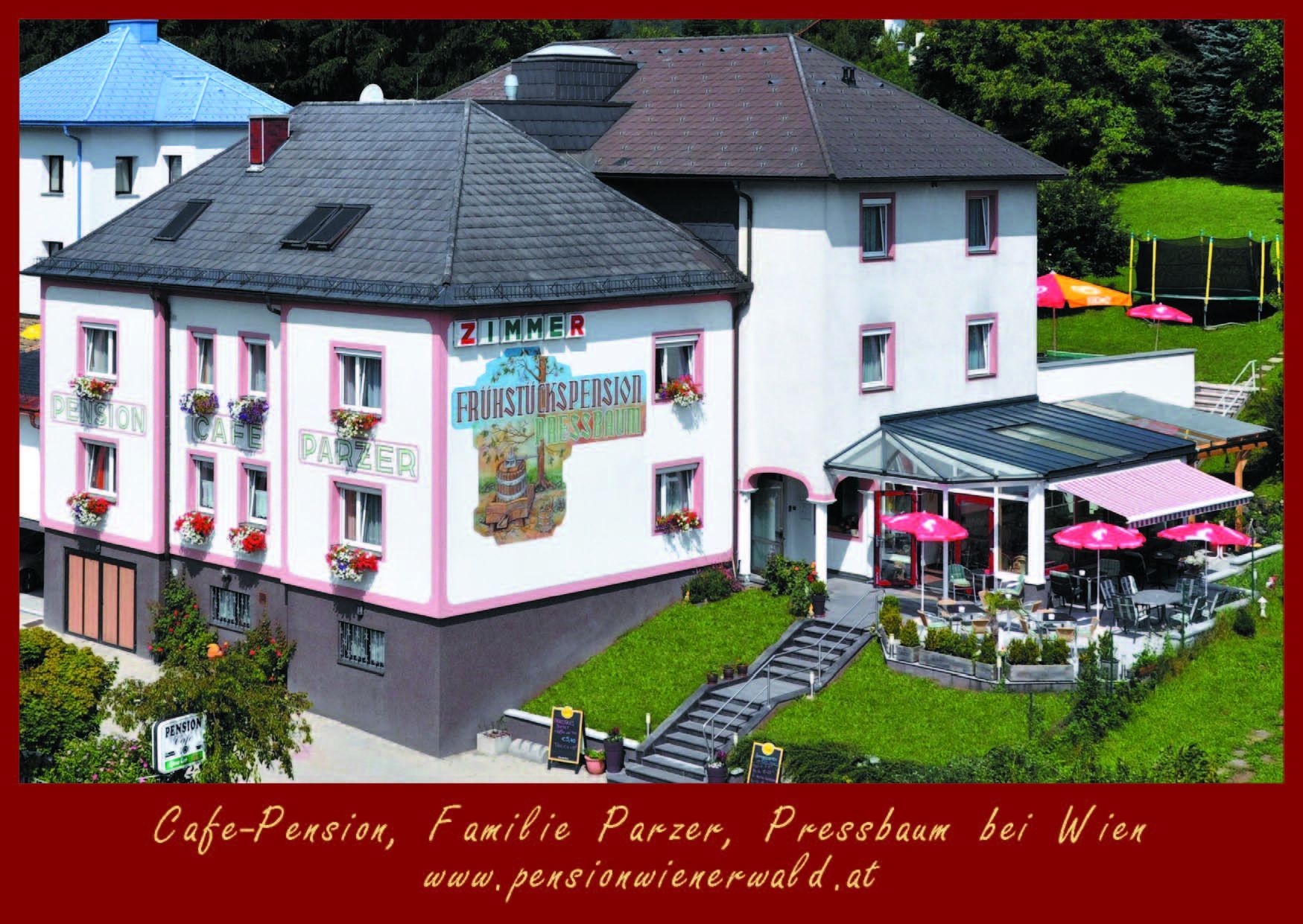 Außenansicht der Cafe-Pension Parzer mit Terrasse und Sonnenschirmen.